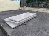 un banc en pierre situé au milieu d'un parking