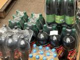 many bottles of soda sitting on a pallet in a store