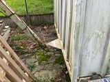 a broken toilet in the yard next to a building