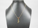 un collier en or orné d'une pierre rouge autour du cou d'un mannequin