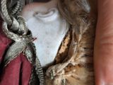 a close up of a person ' s hand holding a doll