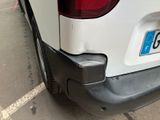 the rear end of a white car with a number plate on it ' s bumper