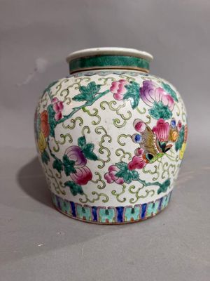 a white vase with colorful flowers on it sitting on a table
