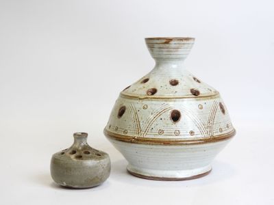 two vases sitting next to each other on a white surface