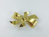 a close up of a gold bow on a white surface