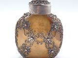 un vase ancien en argent et en or, surmonté d'une perle rouge