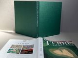 le livre est ouvert sur une table, à côté d'une lampe
