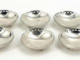 six silver plated bowls on a white surface with a white background