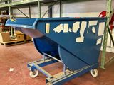 une benne bleue posée sur un chariot dans un entrepôt