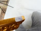 une personne qui tient un objet en or dans la main