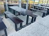 des tables et des bancs devant un bâtiment doté d'une façade vitrée