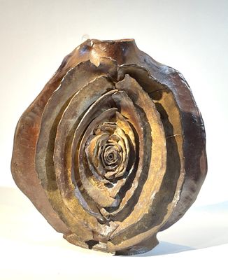 un vase avec une rose au milieu
