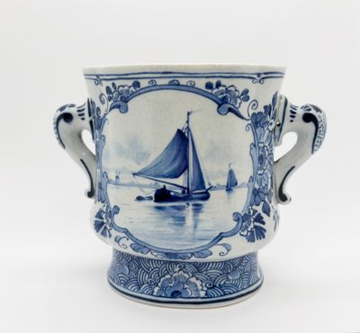un vase bleu et blanc orné d'un voilier