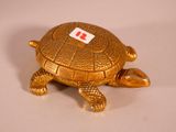 a gold turtle with a red tag on its shell