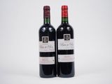 deux bouteilles de vin rouge posées l'une à côté de l'autre sur une surface blanche