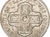 an old silver coin with a cross on it