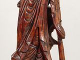 wooden statue of a man with a hat and holding a staff