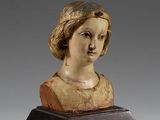 un buste ancien en bois représentant une femme, posé sur un socle en bois