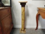 une table en bois sur laquelle se trouve un vase, avec un miroir accroché au mur