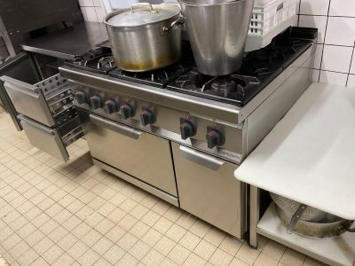 des casseroles et des poêles sont posées sur une cuisinière dans une cuisine