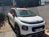 la petite voiture blanche est garée sur le bord de la route