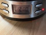 a digital clock on top of a crock pot on a wooden table