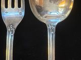 deux cuillères en argent et une fourchette posées sur une table noire