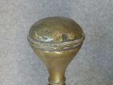someone is holding a brass bell in their hand on a gray background