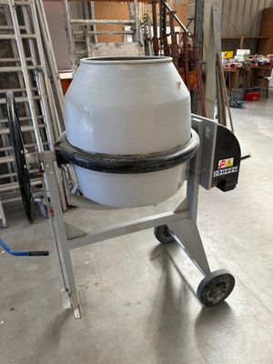 une bétonnière posée sur un chariot dans un entrepôt