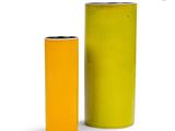 two yellow vases sitting next to each other on a white surface