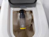 a white toilet with a black lid and a yellow handle