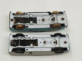two toy cars sitting side by side on a white surface