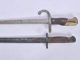 pair of old and worn swords on a white surface