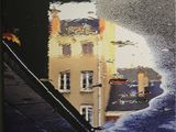 reflet d'un bâtiment dans une flaque d'eau sur un mur