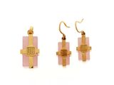 two pieces of gold and pink glass with a cross on them