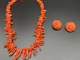 a close up of a necklace and earrings on a table