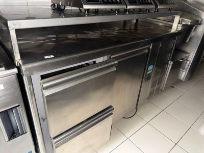 stainless steel counter top in a commercial kitchen with ovens and stoves