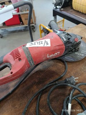 a red and black electric tool sitting on a table
