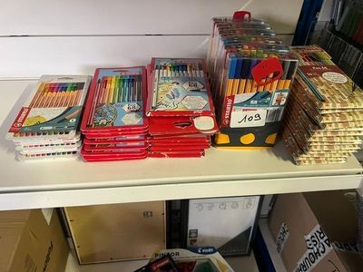 a lot of school supplies on a shelf in a room