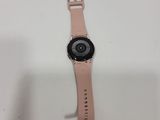 the apple watch is sitting on a white surface with a pink strap