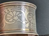 a close up of a silver bracelet with a design on it