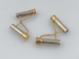 two pairs of gold plated metal rollers on a white surface