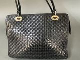 a black handbag with gold hardware on the handles