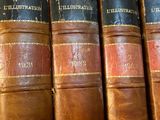 several old books are lined up on a shelf in a library