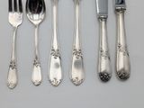 a lot of silver spoons and silverware on a table