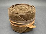 un gros plan sur un rouleau de tissu marron posé sur une surface grise
