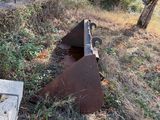 a rusted piece of metal sitting in the middle of a field