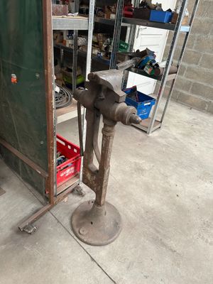 un gros tuyau métallique posé sur un support dans un garage