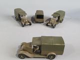 four toy trucks that are sitting on a white surface