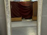 un miroir posé sur le sol devant un mur